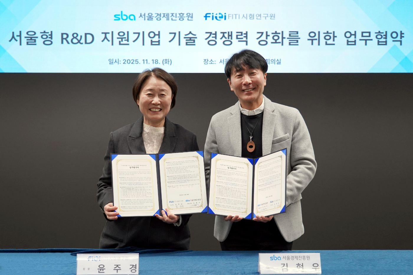 [사진] 윤주경 FITI시험연구원장(왼쪽)과 김현우 서울경제진흥원 대표이사가 업무협약을 체결한 후 기념촬영을 하고 있다..JPG